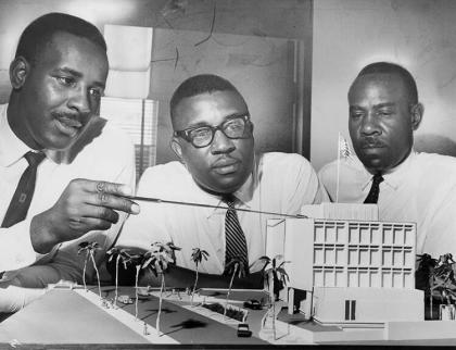 麦迪逊兄弟团队——从左起，伯纳德，朱利安和罗伯特——在20世纪60年代塞内加尔达喀尔的美国大使馆的展示模型上工作
