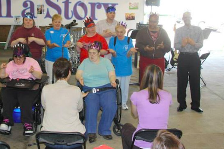 在凯霍加县博览会场地举行的非常特殊的艺术节期间，来自西南成人活动中心的丽莎·利古斯带领唱与手语合唱团。