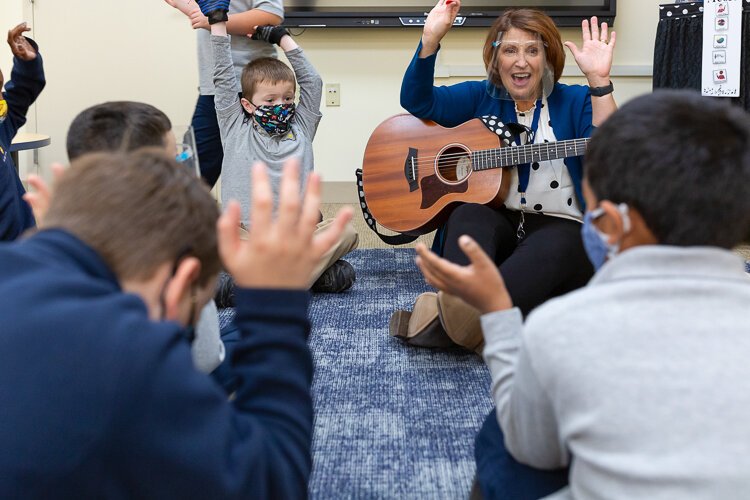 Lisa Ligus带着吉他带领二年级学生参加JB学校西湖校区的音乐和运动活动。