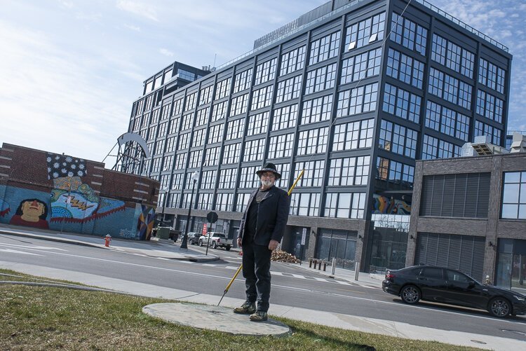 艺术家洛伦·纳吉(Loren Naji)在他的“他们已经着陆”球体雕塑的位置，背景是新建的Intro大楼