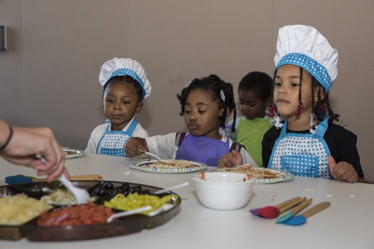 学生们在“孩子在厨房”课程中试用他们的学习材料。