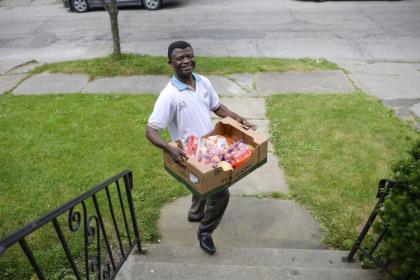 6月11日，大克利夫兰刚果社区主席伊利亚·基德贾纳(Elijah Kidjana)向邻居分发食物。