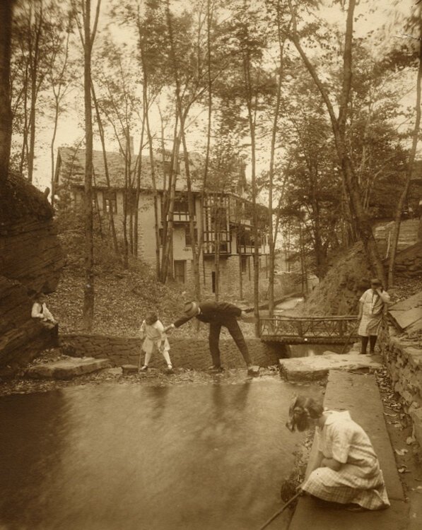 1917年，一名被认为是巴顿·r·戴明的男子和他的侄女们在戴明房子后面的小溪里玩耍