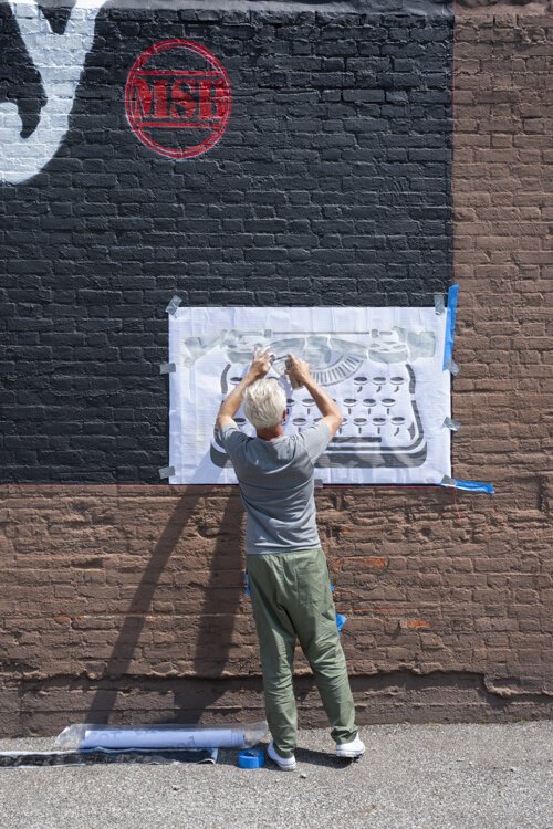 克利夫兰本地人和洛杉矶街头艺术家WRDSMTH在佩恩大街上的“情人”迈克尔·斯坦利致敬壁画上签名。